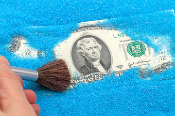 Two US dollars in a blue sand