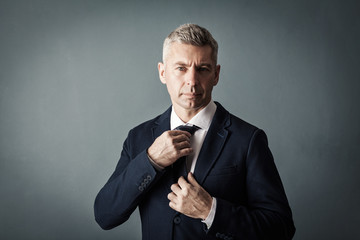 Businessman adjusting his tie