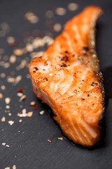 Grilled salmon and spices on black volcanic Board