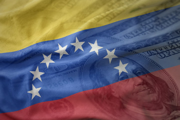colorful waving national flag of venezuela on a american dollar money background. finance concept