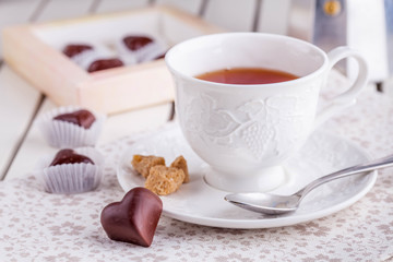 tea in a white cup with chocolate candies