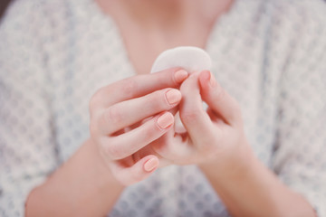 Woman is cleaning nail polish with the cotton pad