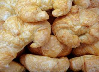 Pile of fresh croissant pastries at the bakery, for background, banner 