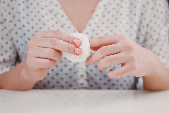 Woman is cleaning nail polish with the cotton pad