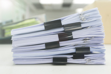 Pile of unfinished documents on office desk, Stack of business paper with black clips.