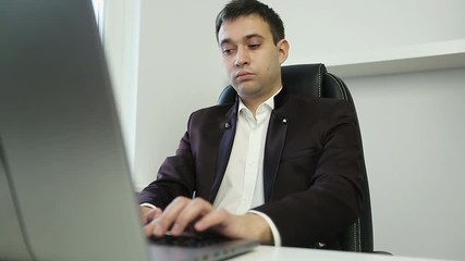 Young man typing on a laptop.