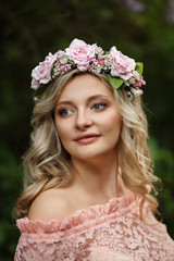 Portrait of beautiful woman with wreath of flowers, spring lady with beauty makeup and tanned skin