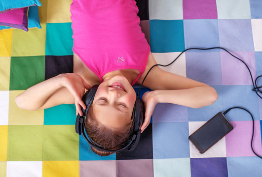 Child student listening to a song on headphones. The concept of learning, music, childhood.