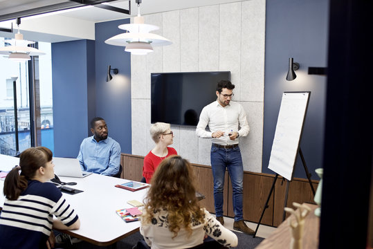 Caucasian businessman giving a presentation to colleagues in a meeting