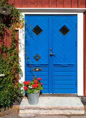 Wooden blue door and bucket with flowers, Kalmar, Sweden. © Tomasz Wozniak