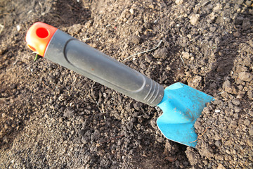 Garden scoop in the loosen soil in the garden