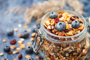 Homemade granola in jar and fresh blueberry