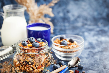 Homemade granola in jar, fresh blueberry and milk