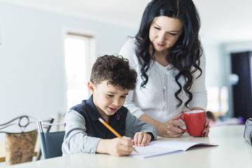 Obraz premium Mother Helping Son for the Homework at home