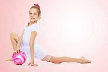 Fototapeta na wymiar Gymnast does exercises with a ball