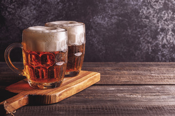 Cold beer in glass with chips on a dark background.