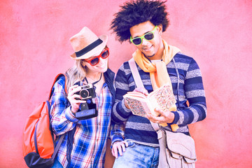 Interracial couple of tourists holding camera and looking tour guide - Attractive latinos traveler...