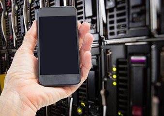 Mans hand holding mobile phone in server room