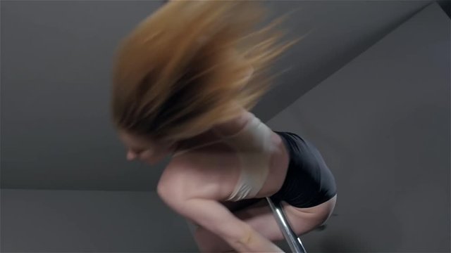 young hot woman in sexy lingerie performs sensual pole dance. Go-go dancer on a floor