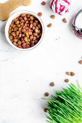 dry dog food in bowl on stone background top view