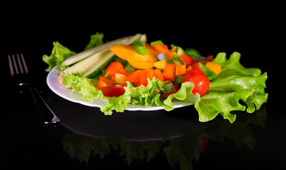 Fresh vegetables on a black background with reflection
