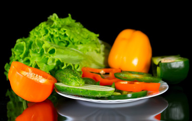 Fresh vegetables on a black background with reflection