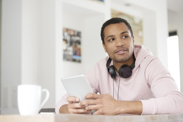 Man with touchpad. Shot of a smiling young afro man using digital tablet while browsing on internet.