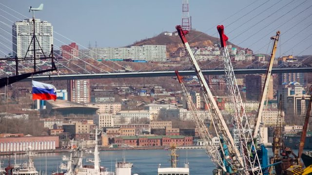 Vladivostok. Zolotoy Rog Bay Bridge. Ships on the Water. Russian Tricolor Flag. City Buildings on Shore. Hill on Background. Autumn