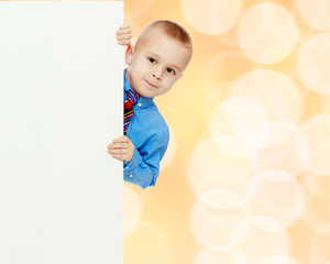 boy peeks out from behind the banner