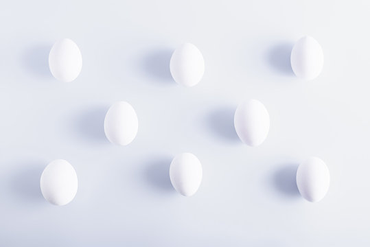 White eggs in a rows on white background © Yulia Mladich