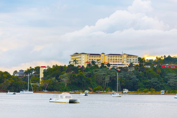 luxury vacation on catamaran near green shore with beautiful architecture