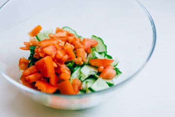 Cucumber and tomatoes sliced in a plate. Bundle for salad on a white background. Vegetarian