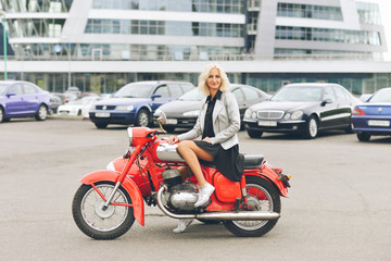 Fototapeta na wymiar Blonde girl on a red motorcycle
