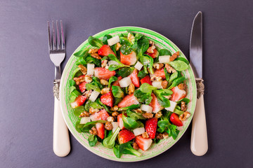 Salad with strawberry, spinach, walnuts and goat cheese