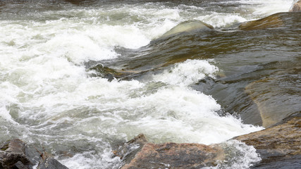 Stromschnelle in einem Fluss mit weißer Gischt