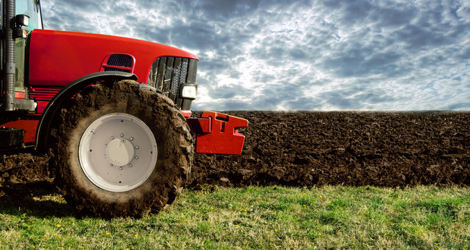 Agriculture. Tractor on the cultivated field. Agronomy, farming concept.