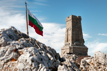 National memorial monument on Shipka peak, Bulgaria and waving Bulgarian flag - obrazy, fototapety, plakaty