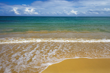 sea surf on the beach. Sand, sea, blue sky and white clouds