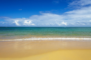 Fototapeta na wymiar sea surf on the beach. Sand, sea, blue sky and white clouds