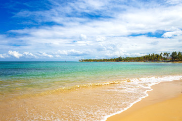 sea surf on the beach. Sand, sea, blue sky and white clouds