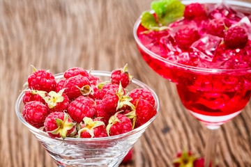 Raspberries fruit in wine glass on wooden background