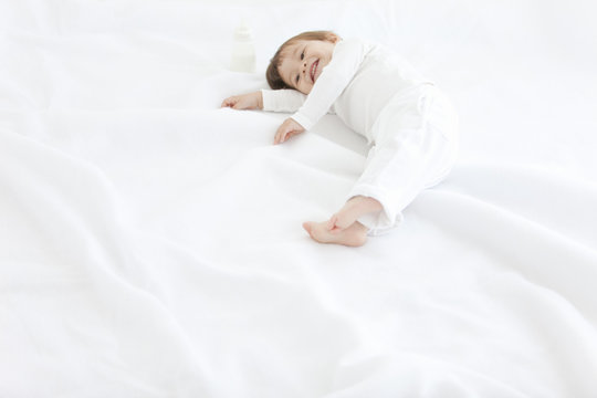 Baby boy lying on duvet