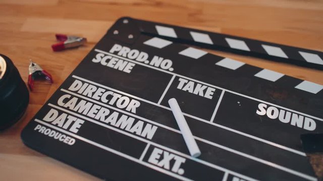  Movie slate and gadget on wooden desk. 4K UHD video.