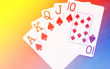 Royal Flush playing cards hand on colorful background