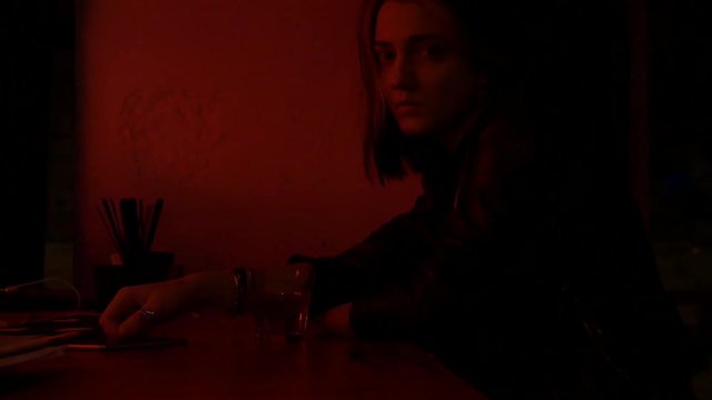 Pretty nice girl in restaurant holding a glass watching in camera. Bar stand with drinks, menu, sign, glass. Red light and glow. 50 fps