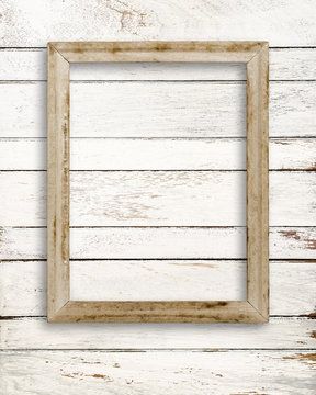 Blank picture frame on white wood wall.