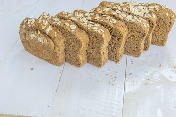 Fresh whole grain bread on white wood background