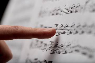 finger pointing to music score