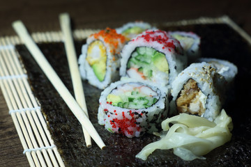 Sushi roll. Sushi roll with shrimp tempura. Fresh and delicious maki and nigiri sushi. Healthy kale and avocado sushi roll with chopsticks. Japanese food. Japanese favorite food sushi maki.