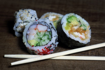 Sushi roll. Sushi roll with shrimp tempura. Fresh and delicious maki and nigiri sushi. Healthy kale and avocado sushi roll with chopsticks. Japanese food. Japanese favorite food sushi maki.